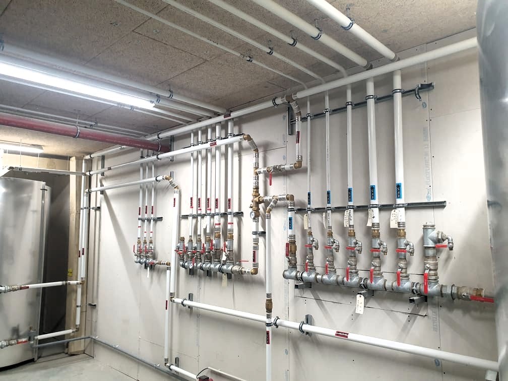 ABS-plomberie_collecteur-distribution-eau-plomberie-Cluses Réseau de distribution d eau sanitaire avec nourrices et vannes d arrêt dans un local technique, dans toute la vallée de l Arve